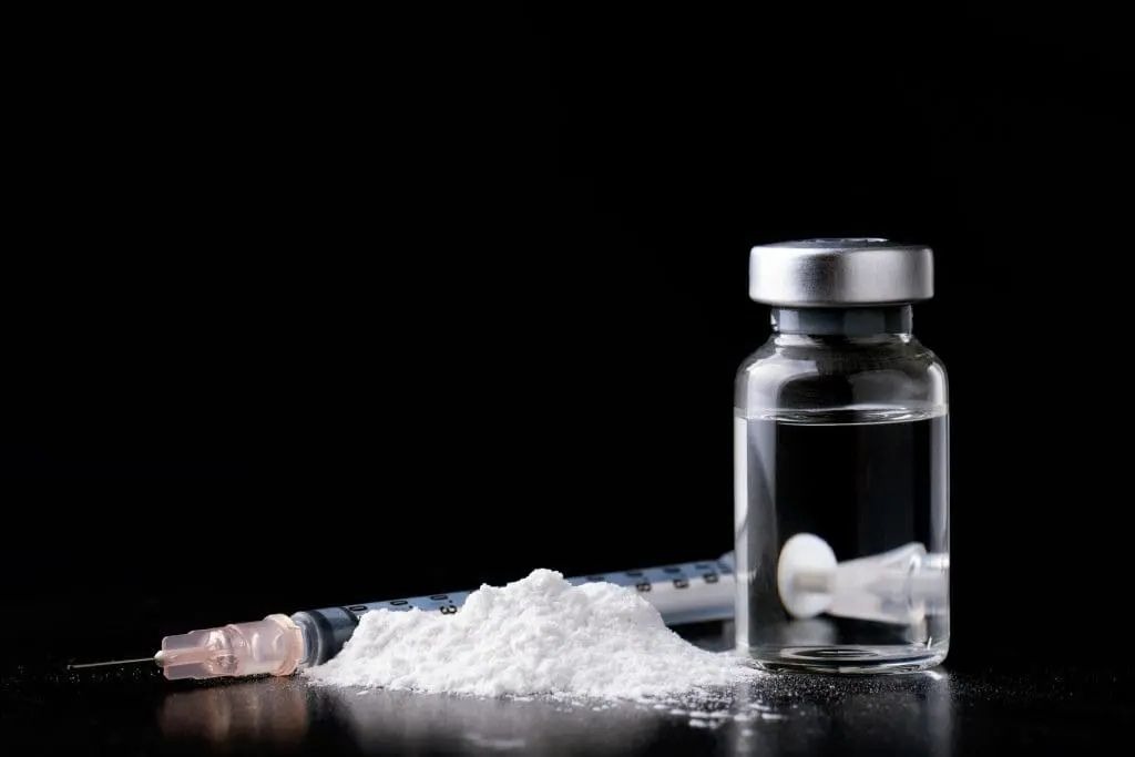 ketamine in powder and liquid form with a needle.